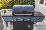 Gas grill with propane included near kitchen for easy access. 